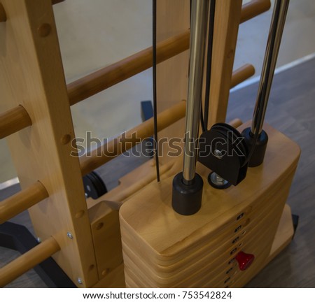 innovative, special wooden weight stack simulator close up in the gym, different weight, stylish design yellow. the view from the top