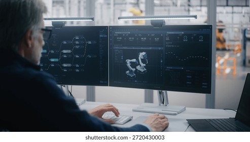 Innovative Workplace, Engineer Using Advanced Software For Robotics. Man Using Advanced Software Manage Robotics, Seated Innovative Dual Screen Workstation. Highlights RD and Technological Innovation.