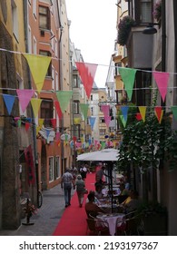 Innsbruck, Austria - August 5, 2022: Multi Colored Flag Garlands Between Building Facades In The Old Town Of Innsbruck 