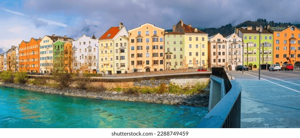 Innsbruck city skyline on a April day with vibrant colorful houses, the snowy Alps mountains, foggy cloudscape, the green Inn River in historic landmark town of Tyrol in western Austria - Powered by Shutterstock