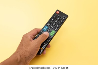 【translation】power, input switch, ground, screen, volume, audio switch, mute, subtitles, channel, program list, recording list, submenu, return, menu, blue, red

Male hand holding a TV remote control.