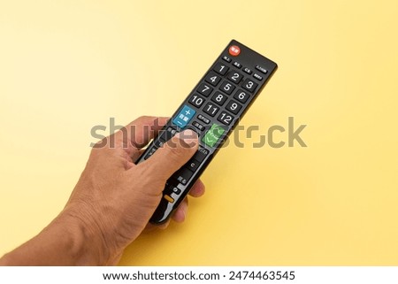 【translation】power, input switch, ground, screen, volume, audio switch, mute, subtitles, channel, program list, recording list, submenu, return, menu, blue, red

Male hand holding a TV remote control.