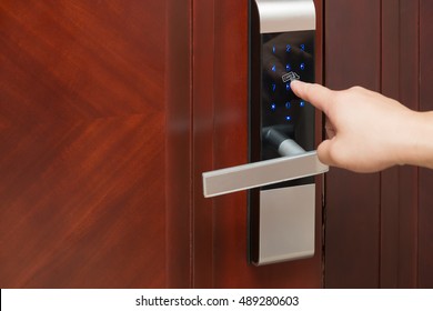 inputing passwords on an electronic door lock - Shutterstock ID 489280603