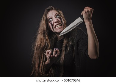 Insane horror zombie girl attacking with a kitchen knife, halloween concept, dangerous and deranged