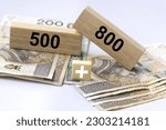 Inscription 800 and 500 plus on wooden blocks with 500 PLN and 800 polish zloty and plus sign. 800 plus is evaluation of the 500 plus program in Poland, state program in the field of social policy, 
