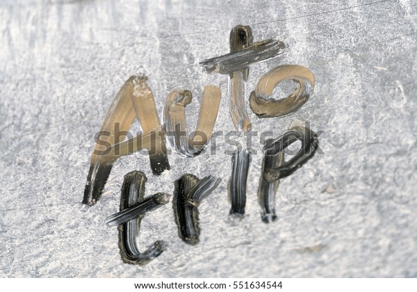 Inscription AUTO TRIP\
on a dirty metal\
surface