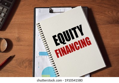 The Inscription EQUITY FINANCE Written In A Notebook, Against The Background Of Office Supplies. Top View Of The Desktop. Business Concept.