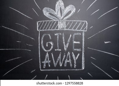 The inscription giveaway is written on a blackboard with gifts. Distribution of gifts. Blog, bloggers, social networks, instagram - Shutterstock ID 1297558828