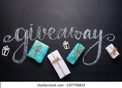 The inscription giveaway written on a blackboard with gifts. The distribution of gifts