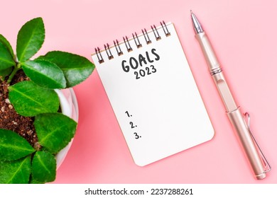 The inscription goals 2023 on notepad on a pink background, top view. - Shutterstock ID 2237288261
