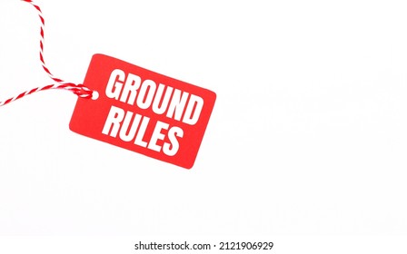 The inscription GROUND RULES on a red price tag on a light background. Advertising concept. Copy space
