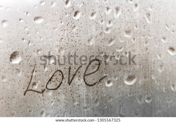 inscription love on the wet window in the rain\
greeting card for Valentines day\
holiday