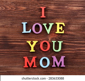 Inscription I LOVE YOU MOM made of colorful letters on wooden background - Powered by Shutterstock