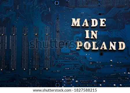 Inscription Made in Poland on a blue electronic printed circuit board. Background with copyspace for design. Polish electronics manufacturing concept.
