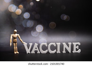 The inscription on dark background with bokeh Covid-19 vaccine. Soft focus. Vaccine and syringe. COVID-19 vaccination concept.
