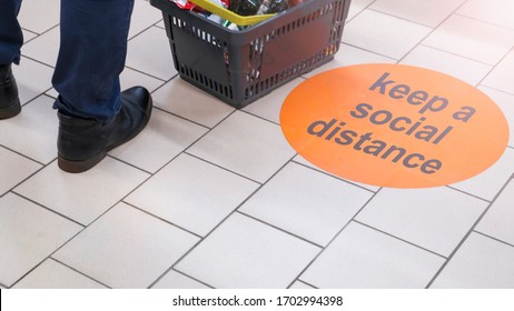 the inscription on the floor of the supermarket: keep a social distance. Selective focus