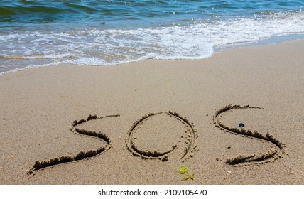 The Inscription On The Sand At The Beach Sos.