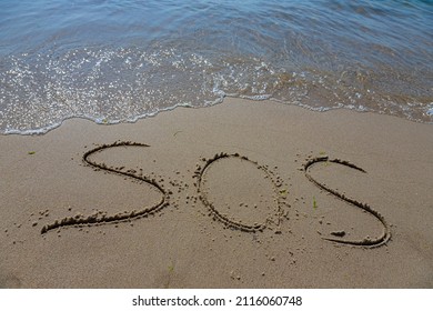 The Inscription On The Sand At The Beach Sos.