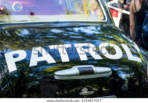 The inscription PATROL\
on a police car. A partial view of a patrol car zoomed in on the\
word \