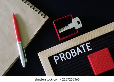 The Inscription Probate On A Black Board Next To A Notepad, Pen And Key In A Red Gift Box. The Concept Of Unexpected Inheritance And Memory Of The Testator. Close-up