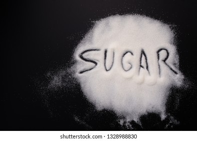 The inscription "Sugar" on sugar on a black background