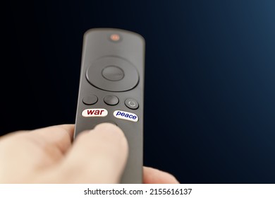 The inscription War in red and the inscription Peace in blue on the buttons of the TV remote control. TV remote in hand with inscriptions on the buttons war and peace.