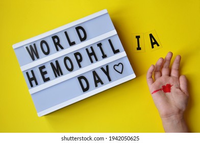 The Inscription World Hemophilia Day. Is Celebrated Annually On April 17.  Hemophilia Occurs Due To Gene Mutations On The X Chromosome And Is Inherited. Child Hand With Red Heart