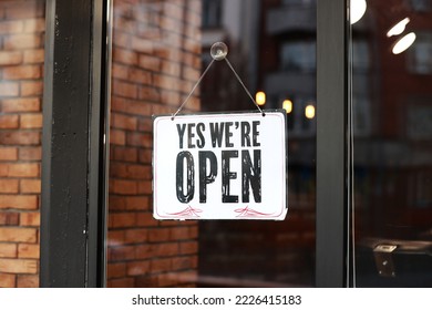 Inscription Yes we're open metal plate with black and white sign on glass door store, cafe, beautystore, barbershop after coronavirus lockdown quarantine. business reopen again. - Powered by Shutterstock