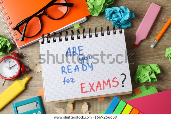 Inscription Are you ready for exams? and different stationary on wooden background, top view