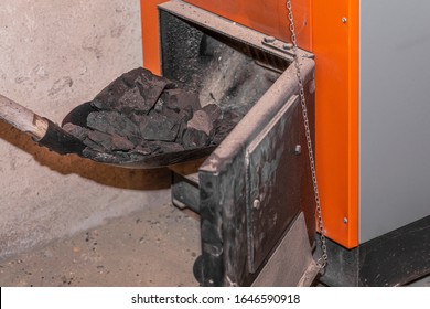 Inserting coal into the boiler with a shovel to heat the room
