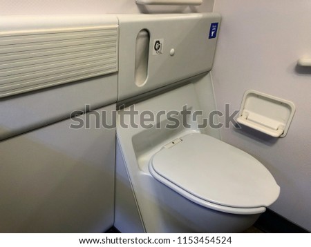 Inside the airplane toilet. Give you a chance to have privacy to handle your nature calls, while are you up in the air. It is a good etiquette to close the cover after used.