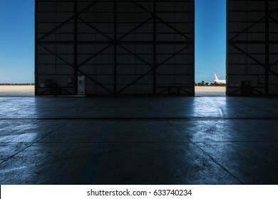 Inside An Airport Hanger Looking Out To The Runway