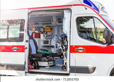 Inside the ambulance, view from the sanitary compartment. Different medical equipment and a stretcher. Selective focus, high key.