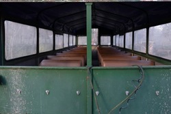 Inside With Artificial Leather Benches From A Long, Somewhat Decayed Metal Covered Wagon. Seen From Behind, Focus On The Green Metal Back