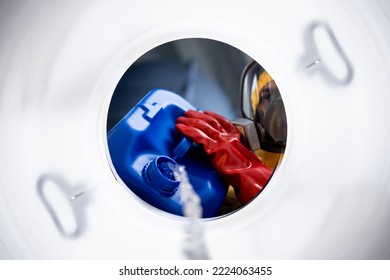 Inside barrel view of worker in protective suit mixing chemicals and making acids for industry. - Powered by Shutterstock