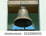 inside the bell tower. A view from below of the big bell. An ancient red brick bell tower in a Catholic church.