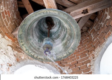 inside the bell tower. View of the large iron bells. Old bell tower of red brick.