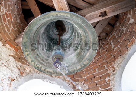 inside the bell tower. View of the large iron bells. Old bell tower of red brick.
