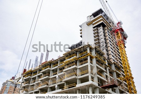 inside building sites under construction and cranes with blue sky background. unfinished cement building at construction site.