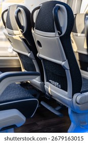 Inside the bus, two comfortable seats are positioned side by side, providing a cozy setting for passengers. Sunlight streams through the windows, enhancing the atmosphere