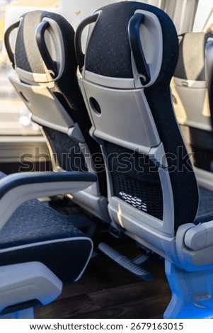 Inside the bus, two comfortable seats are positioned side by side, providing a cozy setting for passengers. Sunlight streams through the windows, enhancing the atmosphere