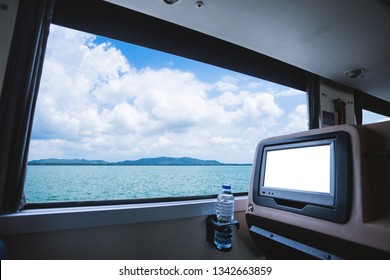 Inside Of The Bus Which Has LCD Screen Blank Rear Seat For Entertainment With A Bottle Of Water And Window View Of Beautiful Landscape Nature The Sea With Sky Cloud, Figure Tourism Road Trip Concept.