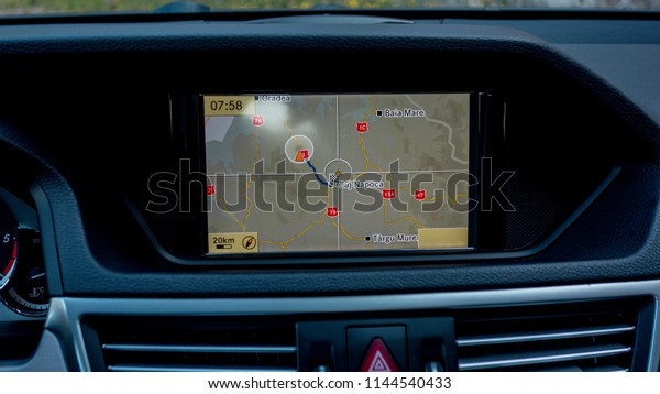 Inside car screen multimedia\
system with application navigation above air vents. Close up of\
multimedia system interface - indicating Cluj-Napoca city\
position