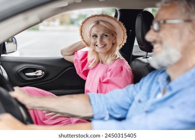 Inside the car view of a smiling, retired, elderly couple wearing casual clothes, after grocery shopping - Powered by Shutterstock