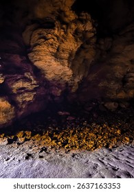 Inside a cave with light peeking through. The wet bumpy and sometimes slice floor can be treacherous to navigate. A nice place to cool off from summer heat.