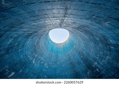 The inside of a cooling tower with a light in the background