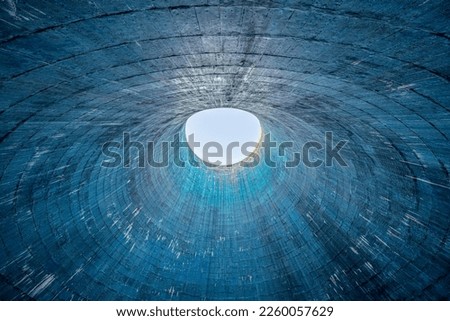The inside of a cooling tower with a light in the background