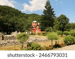 Inside the courtyard, garden of the Patriarchate of Pec Monastery, view between the trees onto the Church Complex, outside Peja, Kosovo 2022