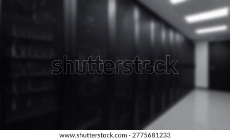 Inside a dark server room, rows of data storage equipment are visible. The image shows a modern data center with servers and network infrastructure.
