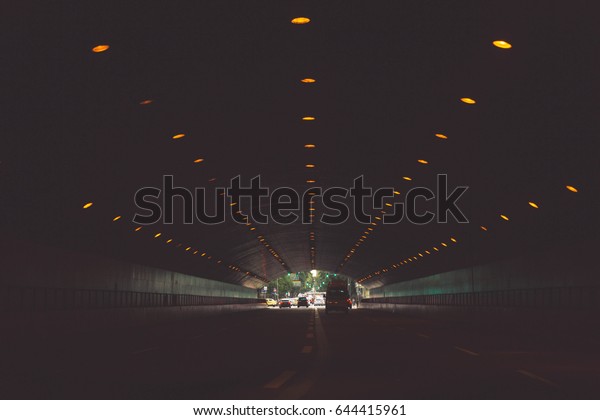 Inside a dark tunnel of passage of cars. / Transit\
of cars. / Tunnel of\
cars.